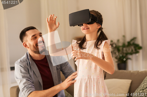 Image of father and daughter playing video game at home