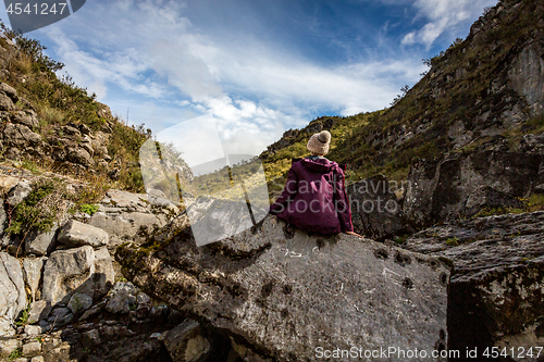 Image of Woman sitting on rock with sea fossils more than 1200 mtrs above sea