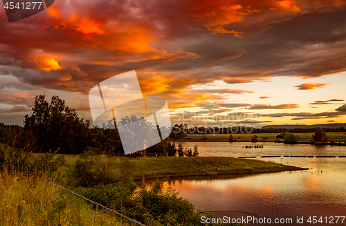 Image of Sunset sky over rural lakes with mountain backdrop