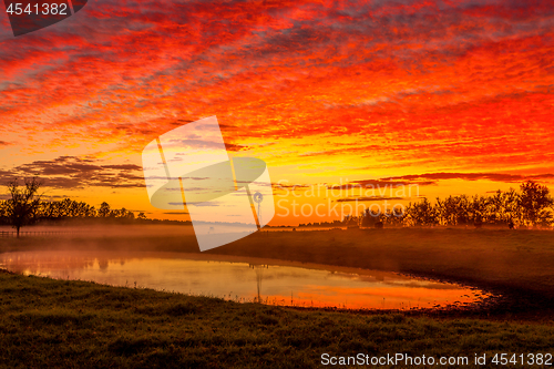 Image of Blazing red sunrise skies across rural landscape Australia