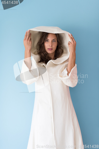 Image of woman in a white coat with hood isolated on blue background