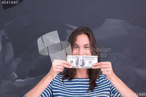 Image of woman holding a banknote in front of chalk drawing board