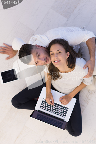 Image of couple using tablet and laptop computers top view