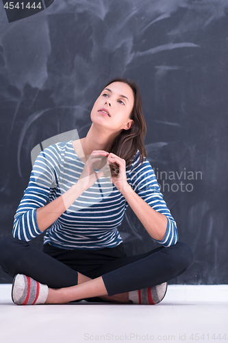 Image of woman sitting in front of chalk drawing board