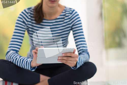 Image of young women using tablet computer on the floor