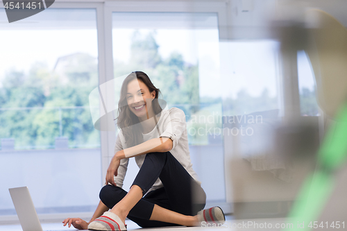 Image of young women using laptop computer on the floor