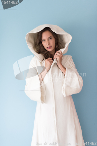 Image of woman in a white coat with hood isolated on blue background