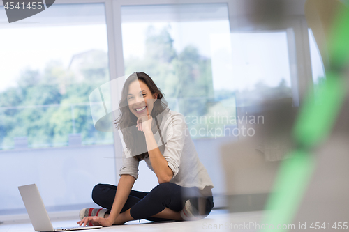 Image of young women using laptop computer on the floor