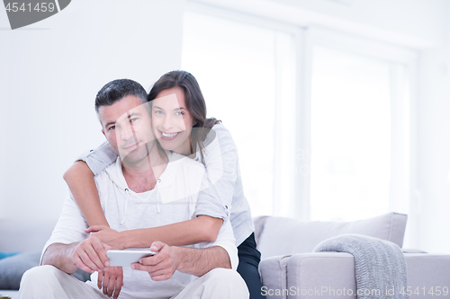 Image of happy couple using mobile phone at home