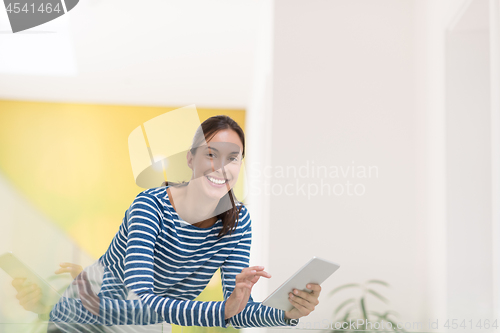 Image of young woman at home websurfing