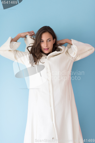 Image of woman in a white coat with hood isolated on blue background