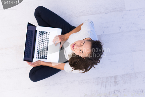 Image of women using laptop computer on the floor top view
