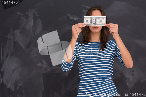 Image of woman holding a banknote in front of chalk drawing board