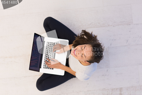 Image of women using laptop computer on the floor top view
