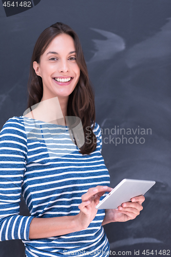 Image of woman using tablet  in front of chalk drawing board