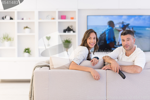 Image of Young couple on the sofa watching television