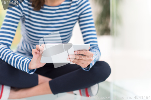 Image of young women using tablet computer on the floor