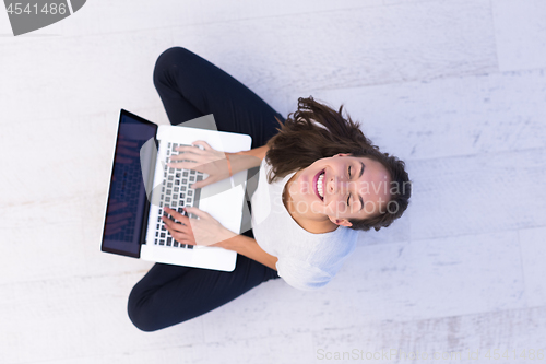 Image of women using laptop computer on the floor top view