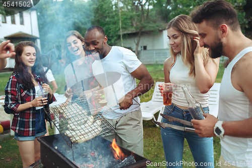 Image of Group of friends making barbecue in the backyard. concept about good and positive mood with friends