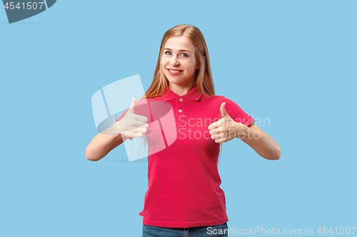 Image of The happy business woman standing and smiling against blue background.