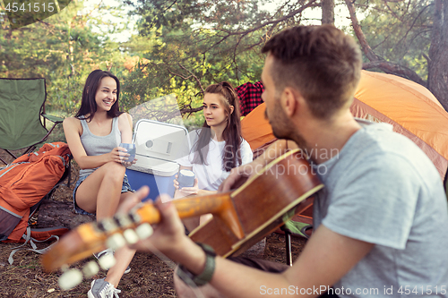 Image of Party, camping of men and women group at forest. They relaxing, singing a song