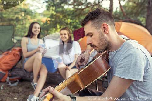 Image of Party, camping of men and women group at forest. They relaxing, singing a song