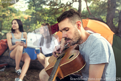 Image of Party, camping of men and women group at forest. They relaxing, singing a song