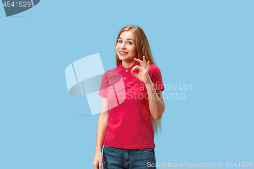 Image of The happy business woman standing and smiling against blue background.