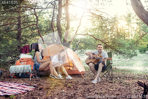 Image of Party, camping of men and women group at forest. They relaxing, singing a song