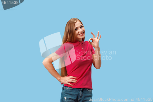 Image of The happy business woman standing and smiling against blue background.