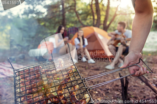 Image of Party, camping of men and women group at forest. They relaxing, singing a song and cooking barbecue