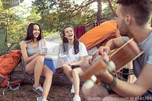 Image of Party, camping of men and women group at forest. They relaxing, singing a song