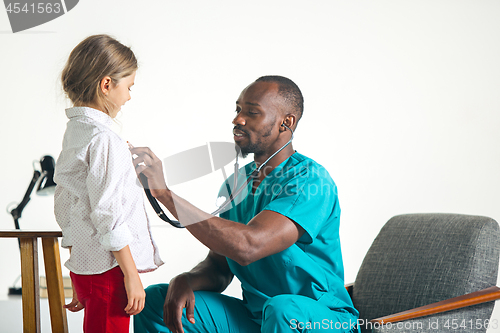 Image of healthcare and medical concept - doctor with stethoscope listening to child chest in hospital