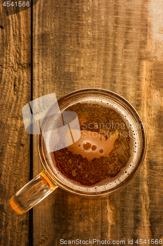 Image of American beer concept, USA silhouette on foam in beer glass on wooden table.