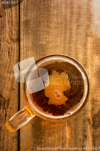 Image of Germanic beer concept, Germany silhouette on foam in beer glass on wooden table.