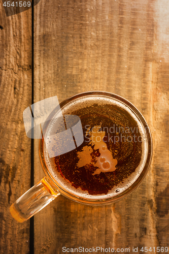 Image of English beer concept, Great Britain silhouette on foam in beer glass on wooden table.