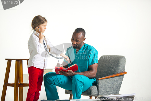 Image of healthcare and medical concept - doctor and girl with stethoscope in hospital