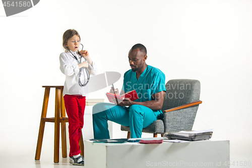 Image of healthcare and medical concept - doctor and girl with stethoscope in hospital