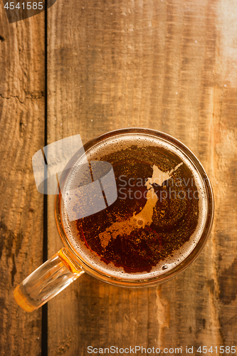 Image of japanese beer concept, silhouette on foam in beer glass on wooden table.