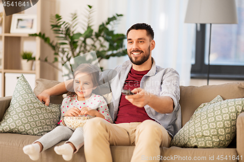 Image of happy father and daughter watching tv at home