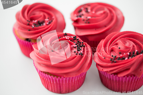 Image of close up of cupcakes with red buttercream frosting