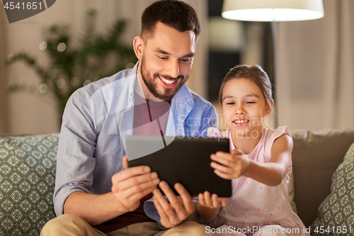 Image of father and daughter with tablet computer at home