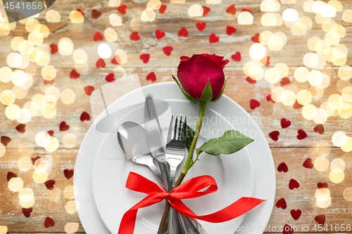 Image of close up of red rose flower on set of dishes