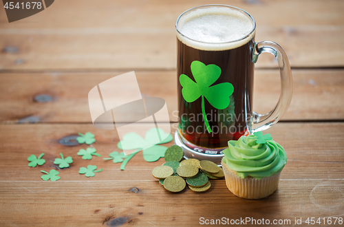 Image of shamrock on glass of beer, green cupcake and coins