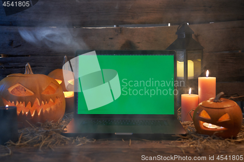 Image of Jack-O-Lantern Halloween pumpkins on rough wooden planks with candles