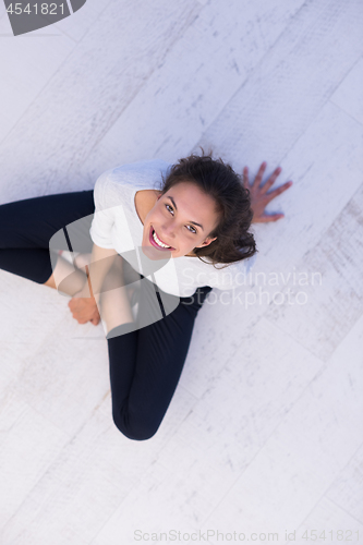 Image of top view of young woman sitting on the floor