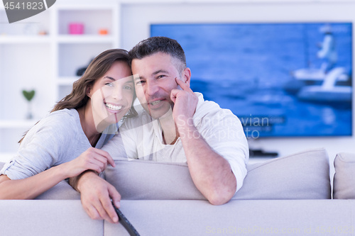 Image of Young couple on the sofa watching television