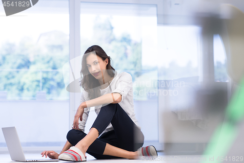 Image of young women using laptop computer on the floor
