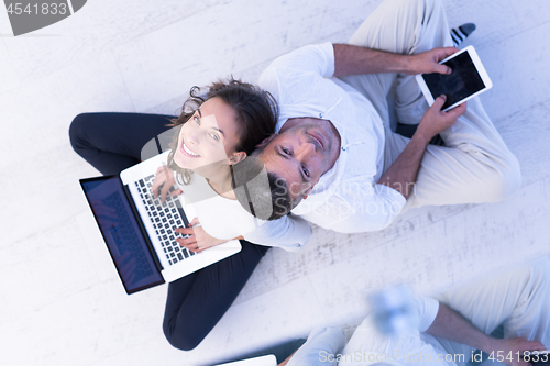 Image of couple using tablet and laptop computers top view