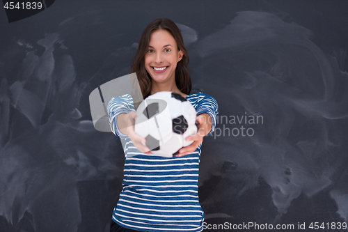 Image of woman holding a soccer ball in front of chalk drawing board
